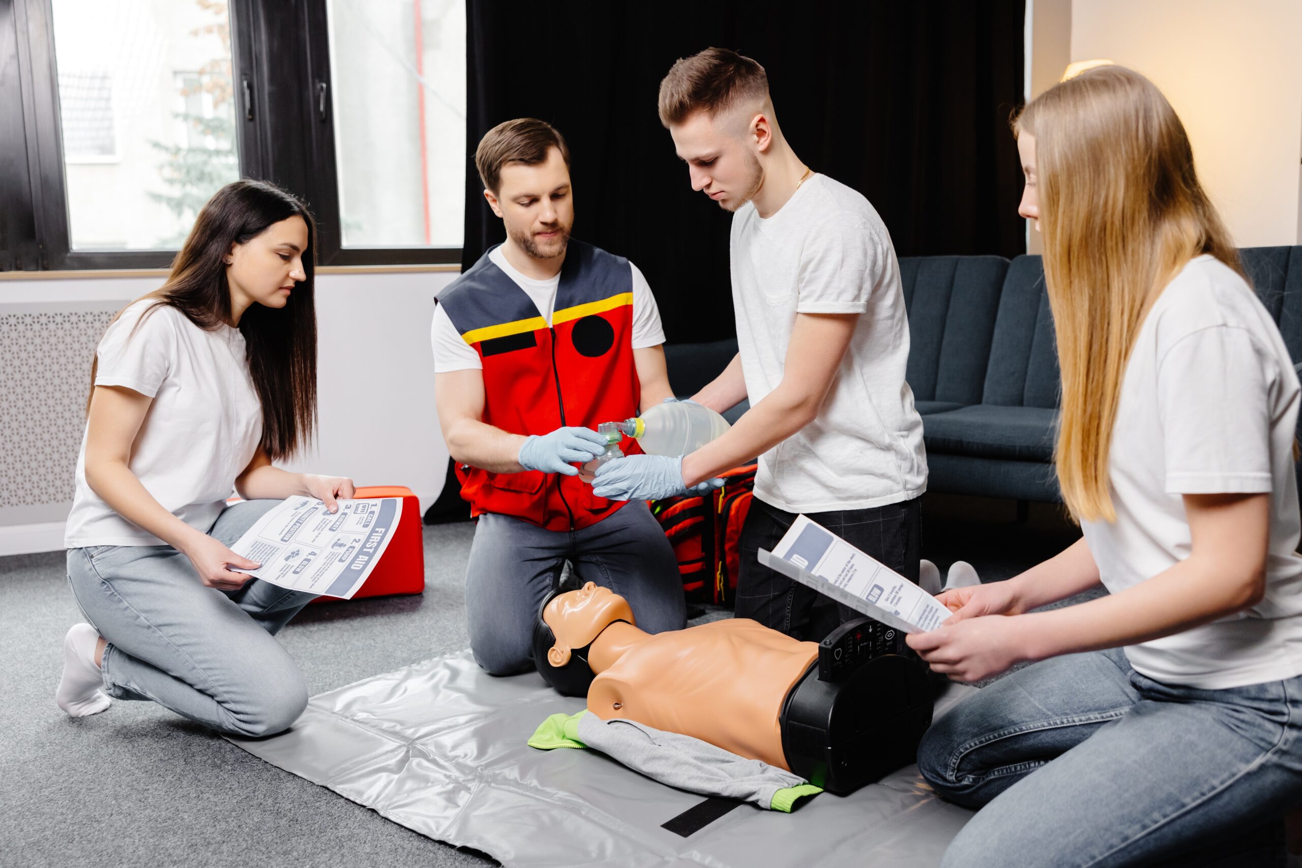 Young,Man,Instructor,Helping,To,Make,First,Aid,Heart,Compressions
